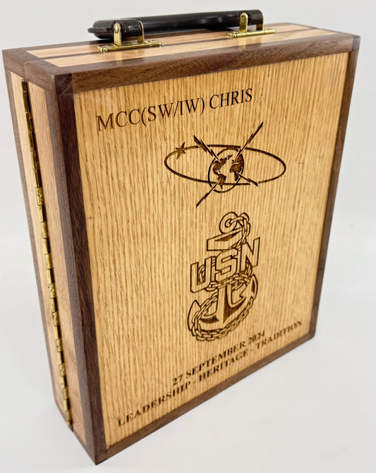 A wooden Navy vessel box with a black handle on top, featuring engraved US Navy graphics and the text on a oak wood grain front panel.