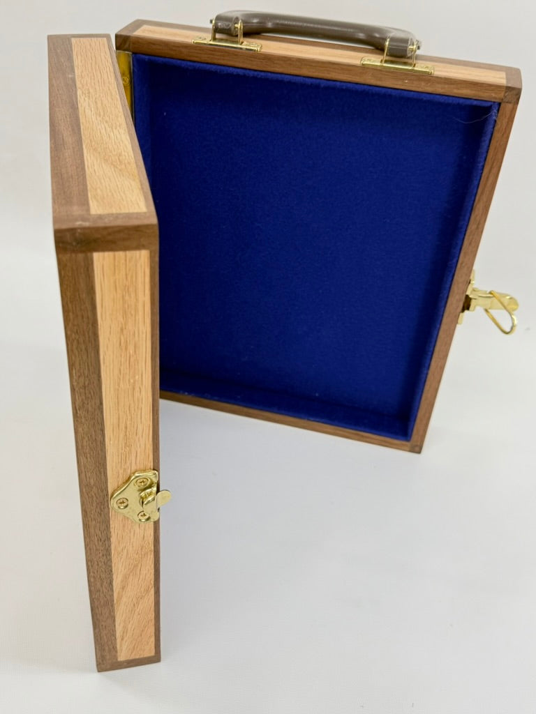 A wooden Navy vessel presentation box with an open lid, featuring a dark brown wood exterior, a light wood inlay on the front panel, a dark handle, and a bright blue velvet interior. It has brass latches and hinges.